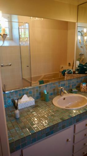 a bathroom counter with a sink and a mirror at Maison Thoumieu in Azereix