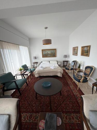 ein Wohnzimmer mit einem Bett, einem Tisch und Stühlen in der Unterkunft Ellados in Strovolos