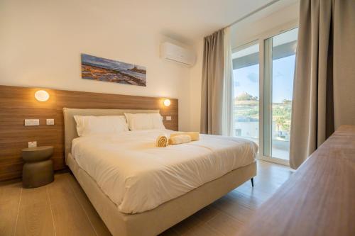 a bedroom with a large bed and a large window at Vista Point Suites in Marsalforn