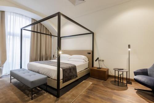 a bedroom with a canopy bed and a couch at Apartments Kozmo Residences Budapest in Budapest