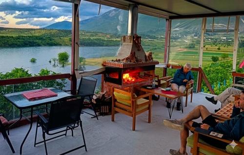 a group of people sitting on a porch with a fireplace at SuperPanorama GuestHouse in Kukës
