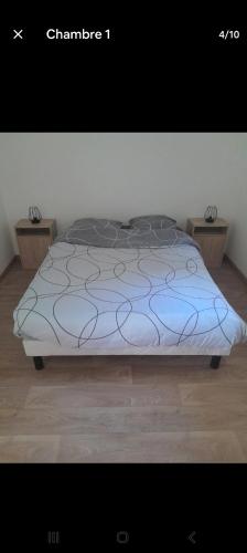 a bed with a blue comforter in a room at Charmante maison in Sussac