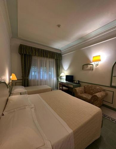 a hotel room with a large bed and a desk at Grand Hotel Terme in Riolo Terme