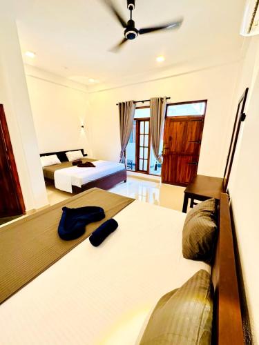 a bedroom with two beds and a ceiling at Surf del mar in Arugam Bay