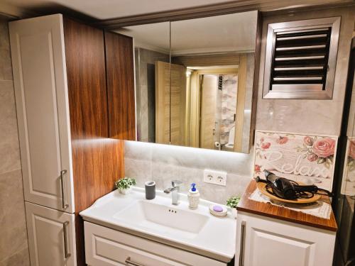 a bathroom with a sink and a mirror at Elegant & Cozy Retreat Home, City Center Gem, At the Seaside, Steps from the Tram in Konak