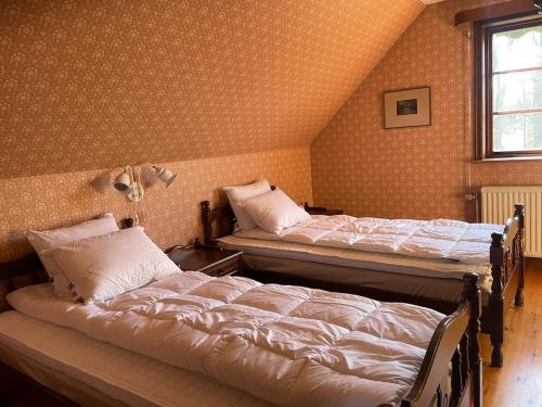 two twin beds in a room with a attic at Thorsagården in Listerby