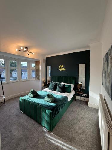 a bedroom with a large green bed and a desk at Emerald Manor - Free Parking - Free Wifi in Solihull