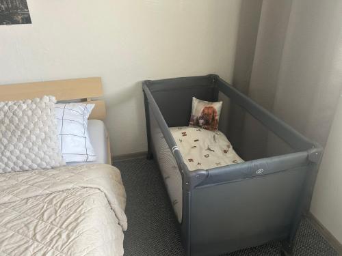 a baby crib in a bedroom with a bed at Privát Nikodém in Veľký Slavkov