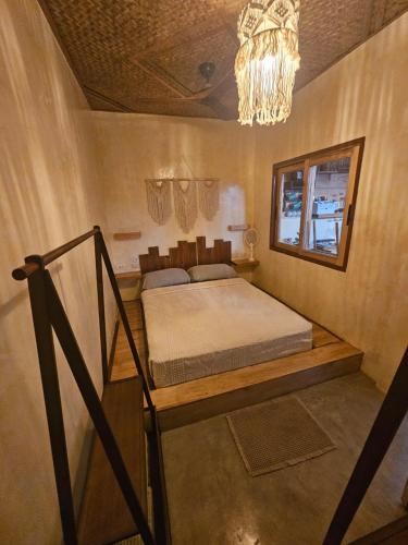ein Schlafzimmer mit einem Bett und einem Kronleuchter in der Unterkunft Lula House in El Nido