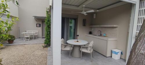 a patio with a table and a kitchen in a house at Ammouda Villas in Ormos Panagias