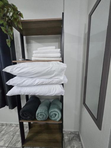 a stack of towels in a bathroom with a mirror at Loft Recanto Dos Cavalheiros! Com Ar Condicionado! in Macaé