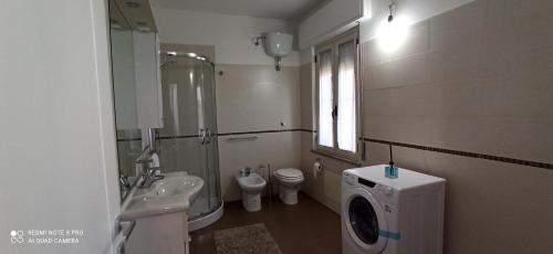 a bathroom with a sink and a washing machine at Neapolis casa vacanza in Terralba