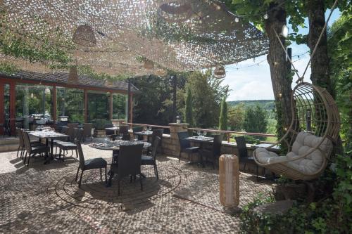 a restaurant with tables and chairs on a patio at Logis Hostellerie la Chaumière in Arsonval