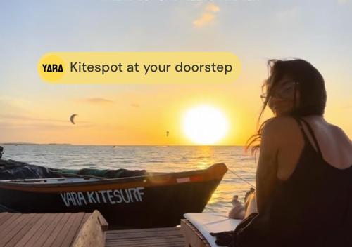 a woman sitting next to a boat on the beach at Yara Floating Villa in Guriú