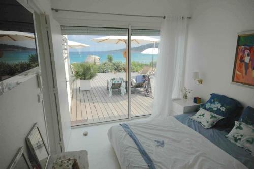 a bedroom with a bed and a view of the ocean at Sur la plage in Lumio