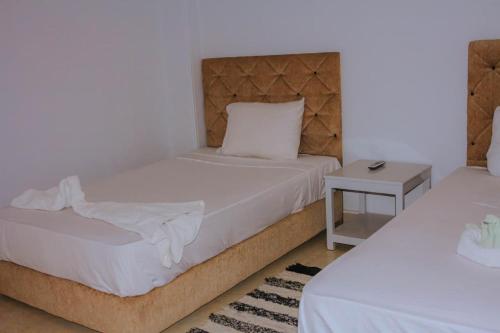 a bedroom with two beds and a night stand at Villa Abo Ishak in Luxor