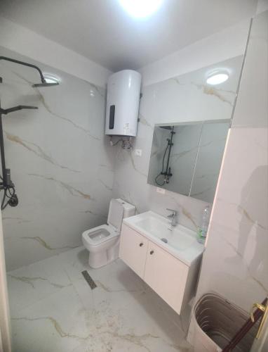 a white bathroom with a toilet and a sink at SeaView 7 Floor -No Elevater in Durrës
