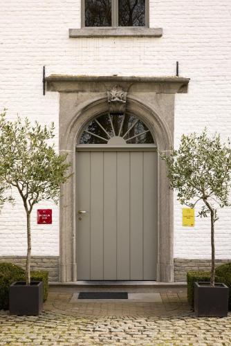 a white garage door with two trees in front of a building at B&B Alexandre in Herzele
