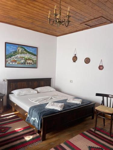 a bedroom with a bed and a chandelier at Guest House Genti in Berat