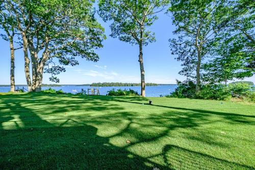 a grassy field with trees and water in the background at Modern Ocean Front Home 4 bed, 5 bath Freeport in Freeport
