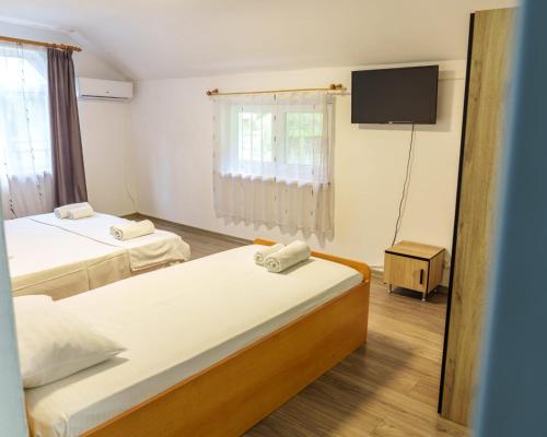 a room with two beds and a flat screen tv at CasaMarinela in Orşova