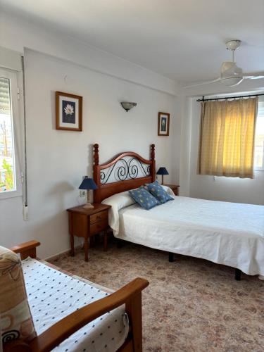 a bedroom with two beds and a chair at Apartamento vacacional Jávea in Jávea