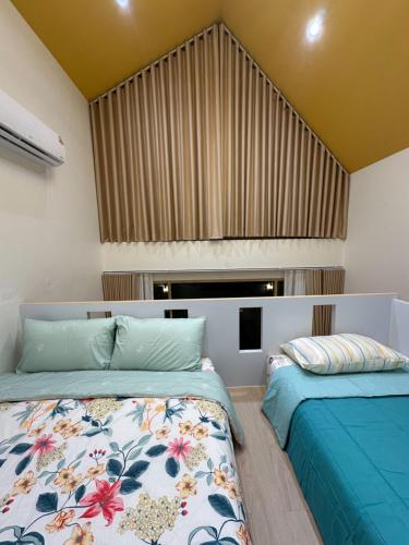 a bedroom with two beds and a window at Rimna Pool Villa in Hat Yai
