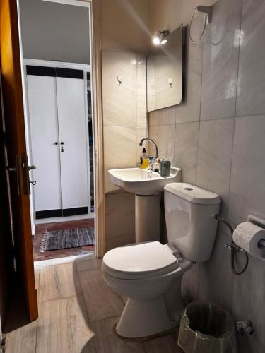 a bathroom with a white toilet and a sink at Blue Note in Mytilene