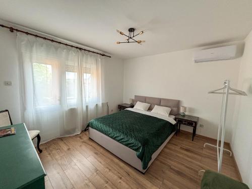 a bedroom with a bed with a green comforter at Dabfly Guesthouse & Outdoor Adventures in Ražanj