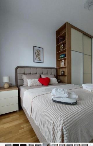 a bedroom with a large bed with a red pillow at D&M Lux1 in Podgorica