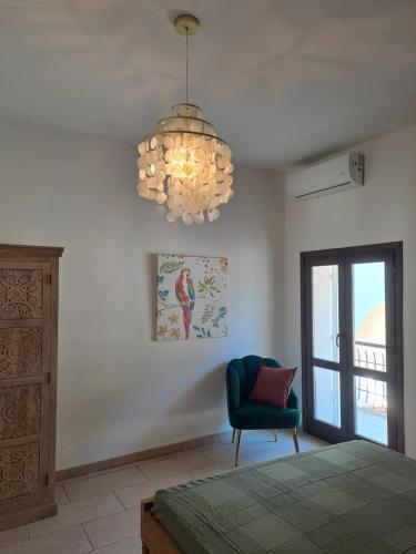 a bedroom with a green chair and a chandelier at Chioma verde in Chioma