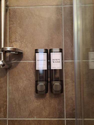 two bottles sitting on the wall of a shower at Chioma verde in Chioma