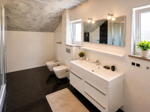 a bathroom with a sink and a toilet and a mirror at Grabovica Sobe-Blue Lake Luxury Rooms in Grabovica