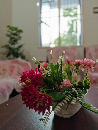 a vase filled with flowers sitting on a table at Parisian Evenings Homestay - Madurai in Madurai