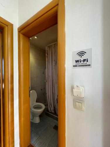 a bathroom with a toilet and a sign on the wall at Blue House 2 in Paliouri