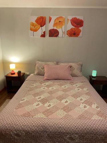 a bed in a bedroom with three pictures on the wall at Hostal El Boldal Marchigüe in Marchihue