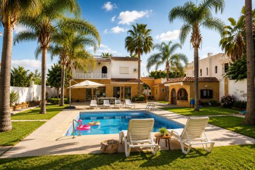 a house with a swimming pool and palm trees at Villa a cabonegro tetouan in Tétouan