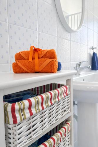 a white basket with towels on a bathroom counter at Tari Home Crotone in Crotone