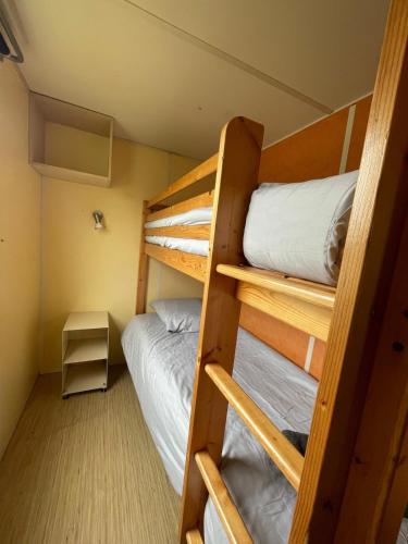 a room with two bunk beds and a bed at Bungalow Neila in Bourbourg