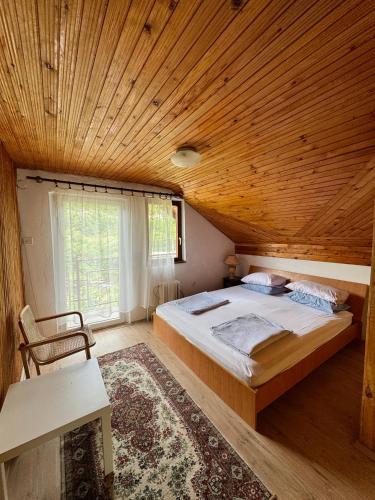 a bedroom with a large bed and a wooden ceiling at Vikendica Jazina in Lastva