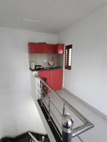 a kitchen with red cabinets and a red stove at Private Duplex Stay with Open Terrace in Meerut