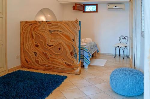 a room with a wooden wall with a blue rug at Dammuso Terra e Mare in Kamma