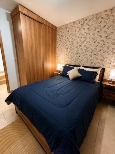 a bedroom with a blue bed with a wooden wall at Casa Costa Azul in Las Dos Palmas