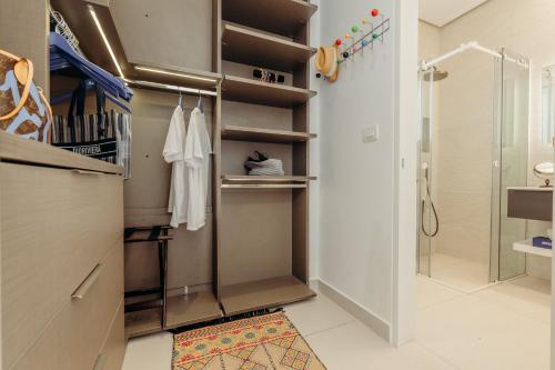 a bathroom with a walk in closet with a shower at Villa Paschalia,Sea View, Pool, Gym, Sleeps 10 in Mikonos