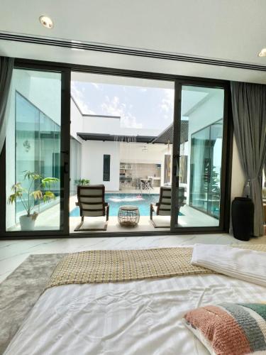 a bedroom with a large window and a pool at Rosella Chalet in Jabal Al Akhdar