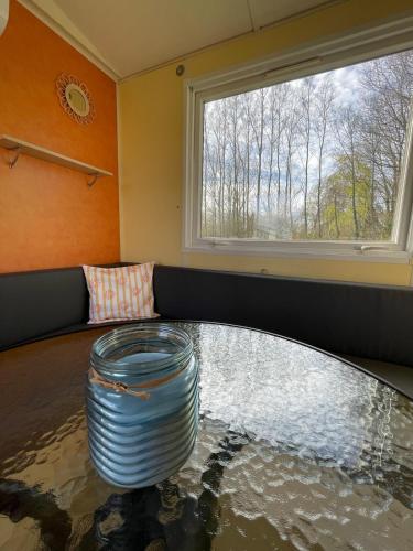 a room with a glass table and a window at Chloe Bungalow in Bourbourg