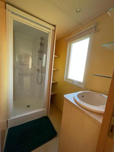 a bathroom with a shower and a sink at Chloe Bungalow in Bourbourg