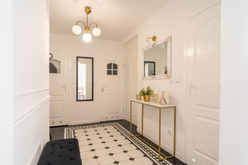 a hallway with white walls and a black and white floor at Apartament nad bulwarem in Lidzbark Warmiński