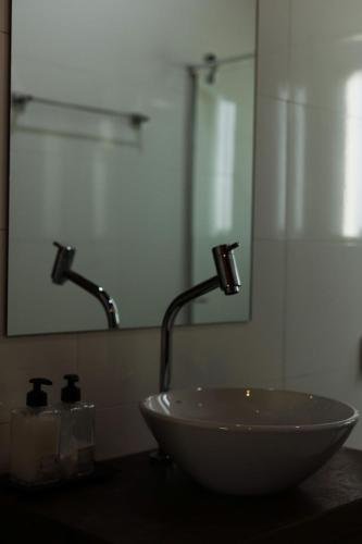 a bathroom with a bowl sink and a mirror at Oliveira mountain House in Tijucas