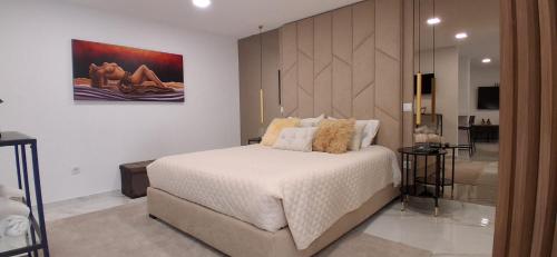 a bedroom with a large bed and a bathroom at Solar da Pedra in Paços de Ferreira